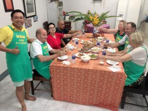 un grupo de personas sentadas alrededor de una mesa comiendo comida en Sao Mai Hotel en Cai Be