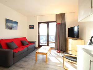 salon z czerwoną kanapą i telewizorem w obiekcie Studio rénové 4 pers avec balcon sud, proche pistes et commerces, casier à skis, parking - FR-1-687-33 w mieście Arâches-la-Frasse