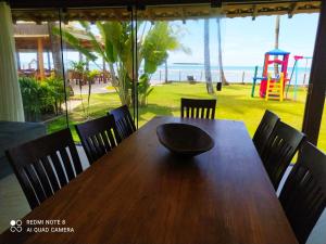 a wooden table with a bowl sitting on top of it at Casa Luxo Frente ao Mar in Arraial d'Ajuda
