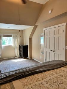 um quarto com uma cama grande e uma janela em The Loft At The Nisqually Highland Ranch em Eatonville