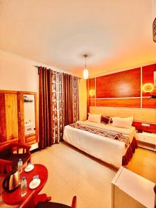 Habitación de hotel con cama y mesa en Jaden Hotel & Lounge - Arusha, en Arusha