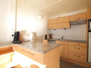 eine Küche mit Holzschränken und einer Arbeitsplatte in der Unterkunft Appartement Flaine, 2 pièces, 6 personnes - FR-1-687-101 in Arâches-la-Frasse