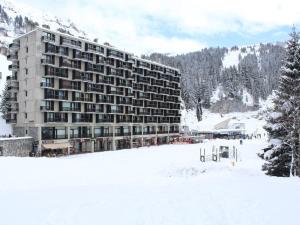 ein großes Gebäude im Schnee mit einem schneebedeckten Feld in der Unterkunft Appartement Flaine, 2 pièces, 6 personnes - FR-1-687-101 in Arâches-la-Frasse