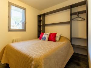 a bedroom with a bed with red pillows on it at Appartement Saint-Lary-Soulan, 2 pièces, 6 personnes - FR-1-296-440 in Saint-Lary-Soulan