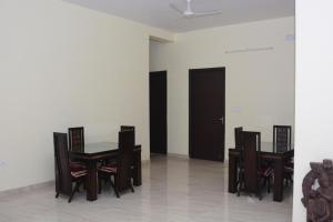 uma sala de jantar com mesa e cadeiras em Comfort Stay em Faridabad
