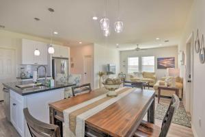a kitchen and living room with a wooden table and a dining room at Bright and Breezy Galveston Retreat with Deck! in Galveston
