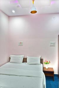 a bedroom with a bed with white walls at B R Inn in Bangalore