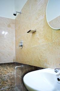 a bathroom with a sink and a mirror at B R Inn in Bengaluru