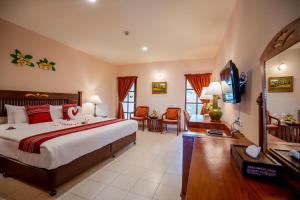 a bedroom with a large bed and a living room at Phuket Leelavadee Hua Ting Resort in Patong Beach