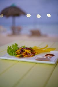 einen Teller mit Essen auf einem Tisch mit Salat in der Unterkunft Mistica Island Hostel - Isla Palma in Isla Palma