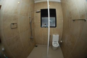 ein Bad mit einer Dusche und einem WC in der Unterkunft Kosgama Riverside Resort in Kosgama