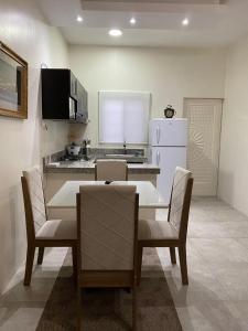 Villa en Salinas vía Punta Carnero في ساليناس: مطبخ مع طاولة وكراسي وثلاجة بيضاء