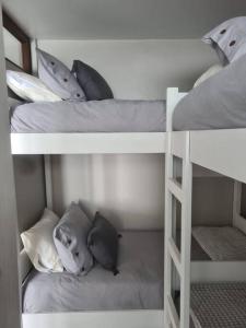two white bunk beds with pillows in a room at Amazing apartment in the best location of El Colorado. in Santiago
