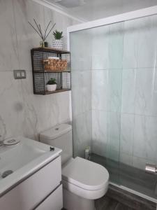 a bathroom with a toilet and a glass shower at Amazing apartment in the best location of El Colorado. in Santiago