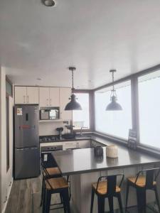 a kitchen with a table and chairs and a refrigerator at Amazing apartment in the best location of El Colorado. in Santiago