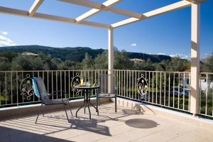 patio con mesa y sillas en el balcón en Villa Iolis, en Lefkada