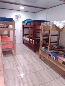 a room with three bunk beds in it at Amaya's Hostel in Jaloba