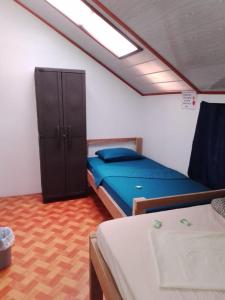 1 dormitorio con 1 cama azul y armario en Amaya's Hostel, en Jaloba