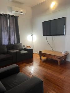 a living room with a couch and a large flat screen tv at Maryborough City Motel in Maryborough