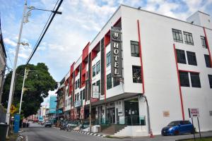 un edificio blanco con un cartel en una calle en J Suites Hotel, en Kuala Terengganu