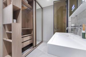 a bathroom with a white tub and a sink at Modern flat with KING SIZE bed and HIGH SPEED Wifi in Dubai