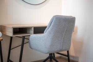 a gray chair sitting next to a desk at Modern flat with KING SIZE bed and HIGH SPEED Wifi in Dubai