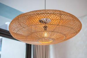 a large wicker light hanging from a ceiling at Modern flat with KING SIZE bed and HIGH SPEED Wifi in Dubai
