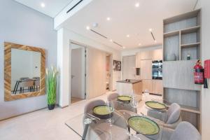 a dining room with a glass table and chairs at Modern flat with KING SIZE bed and HIGH SPEED Wifi in Dubai