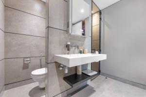 a bathroom with a white sink and a toilet at Modern flat with KING SIZE bed and HIGH SPEED Wifi in Dubai