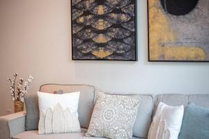 a living room with a couch and two pictures on the wall at Modern flat with KING SIZE bed and HIGH SPEED Wifi in Dubai