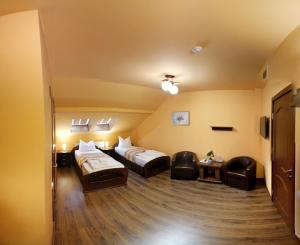 une chambre d'hôtel avec deux lits et deux chaises dans l'établissement Pensiunea Muresul, à Târgu-Mureş
