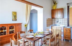 cocina y comedor con mesa de madera y sillas en Cozy Home In Sedini With Wifi, en Sedini