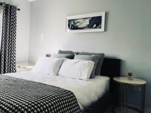 a bedroom with a bed with a black and white comforter at Luxury on 1B Patricia in Ballito