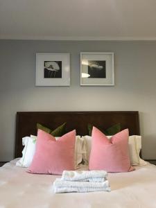 a bedroom with a bed with pink pillows at Luxury on 1B Patricia in Ballito