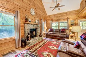 uma sala de estar com lareira e mobiliário de couro em Waynesville Cabin with Covered Deck and Fire Pit! em Lake Junaluska