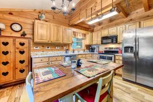 uma cozinha com uma grande mesa de madeira e um frigorífico em Waynesville Cabin with Covered Deck and Fire Pit! em Lake Junaluska