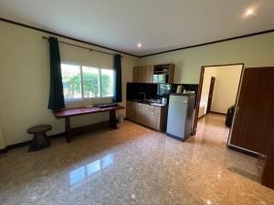 a room with a kitchen with a refrigerator and a window at Garden Resort in Ko Chang