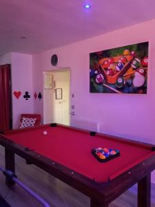 a red pool table in a room with a painting at ESCAPADE en CHAMPAGNE Moments conviviaux entre amis, famille in Épernay
