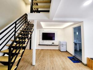 羅東鎮的住宿－幸福YES民宿，一间带楼梯和电视的客厅
