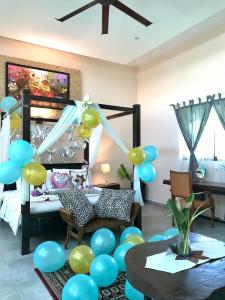 Adagaya Villa Langkawi - Private Pool Villa في بانتايْ سينانج: غرفة بها بالونات زرقاء وأخضر وطاولة