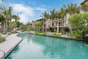 a pool at a resort with palm trees and condos at Holiday Inn Resort Samui Bophut Beach by IHG in Bophut 
