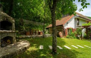 una casa con un cortile con un camino e un albero di Gorgeous Home In Brod Na Kupi With Wifi a Brod na Kupi