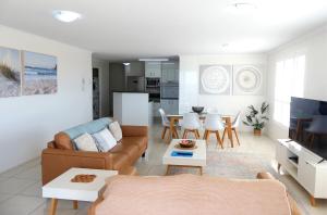 ein Wohnzimmer mit einem Sofa und einem Tisch in der Unterkunft Bargara Blue Resort in Bargara