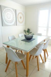 a dining room table with white chairs and a bowl on it at Bargara Blue Resort in Bargara