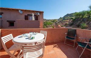 una mesa blanca y sillas en un balcón con TV en Cozy Apartment In Costa Paradiso, en Costa Paradiso 10 fotos más