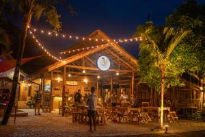 a man standing in front of a building with lights at CocoRico Hostel in San Vicente