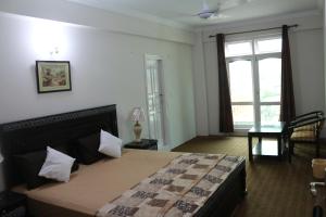 a bedroom with a large bed and a window at Stargaze Hotel & Apartment in Abbottabad