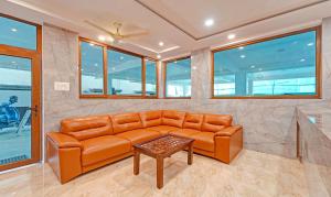 un sofá naranja en una habitación con ventanas en Itsy By Treebo - Elite Inn, en Chennai
