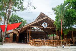 un restaurante con mesas y sillas frente a un edificio en CocoRico Hostel, en San Vicente