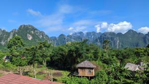 une petite maison au milieu d'une montagne dans l'établissement Vang Vieng Camellia Hotel, à Vang Vieng